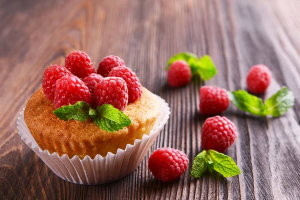 Läckra cupcake med bär och färsk mynta på träbord nära håll — Stockfoto