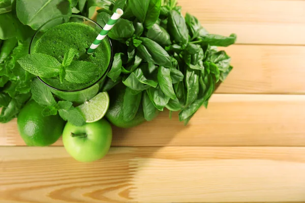 Groene gezond vruchtensap met groenten en kruiden op houten tafel close-up — Stockfoto