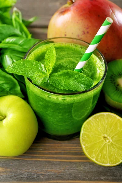 Groene gezond vruchtensap met groenten en kruiden op tafel close-up — Stockfoto