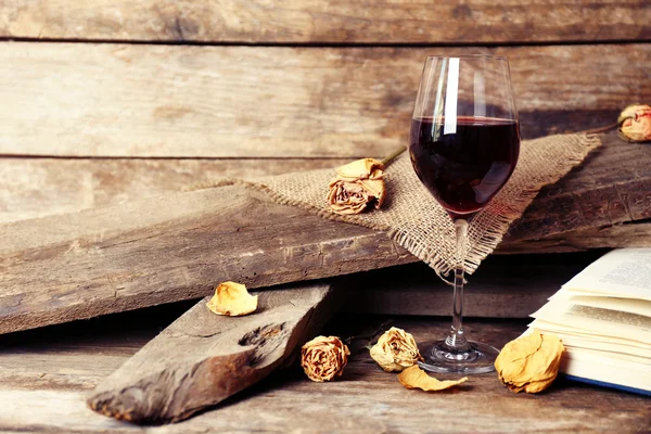 Hermosa composición con copa de vino con libro viejo en la mesa de cerca —  Fotos de Stock