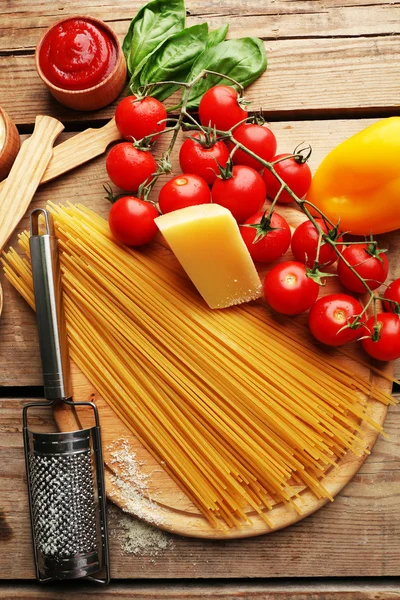 Espaguetis de pasta con tomates, queso y albahaca sobre fondo rústico de madera —  Fotos de Stock