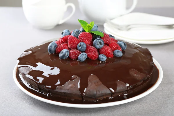 Köstliche Schokoladenkuchen mit Sommerbeeren auf grauem Tischtuch Hintergrund — Stockfoto