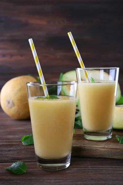 Glasses of melon cocktail on wooden background — Stock Photo, Image