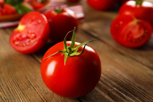 Tomates vermelhos no fundo de madeira closeup — Fotografia de Stock