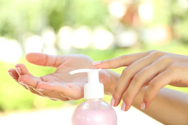 Woman using hand cream outdoors on blurred background — Stock Photo, Image