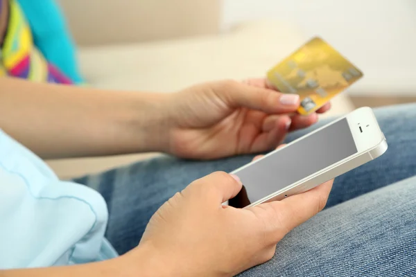 Mãos femininas segurar cartão de crédito e celular, close-up — Fotografia de Stock