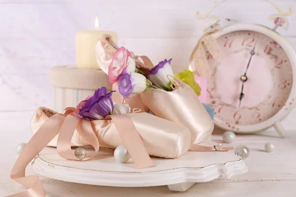 Belle composition de chaussures de ballet décorées avec de vieilles horloges sur fond de bois crémeux — Photo