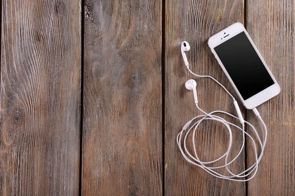 Celular blanco con auriculares — Foto de Stock