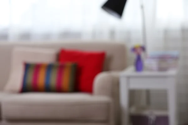 Room interior with comfortable sofa and colourful pillows, blurred — Stock Photo, Image