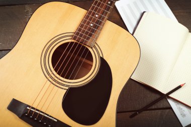 Ahşap arka plan üzerine gitar ve müzik yaprak
