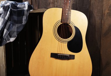 Ahşap duvar arka plan üzerinde sandık gitar ve gömlek yaptı