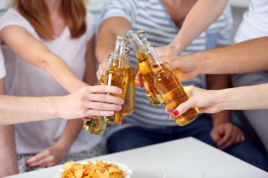 Arkadaşlar el ile şişe bira ve aperatifler, yakın çekim