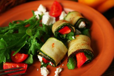 Kabak rulo peynir, biber ve roka ile tabağında, yakın çekim, tablo arka plan üzerinde