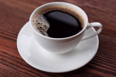 Tahta arka planda bir fincan kahve.