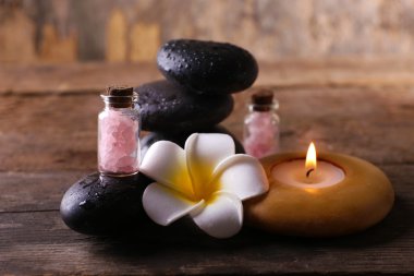 Fragipani çiçek, çakıl ve ışıl ışıl mum ahşap arka plan üzerinde rahatlatıcı