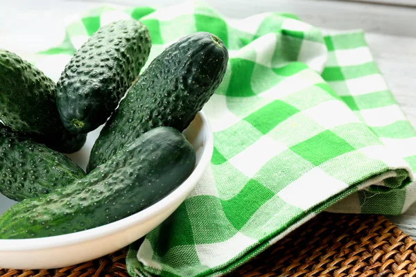 Fresh cucumbers with green checked cotton serviette on the table