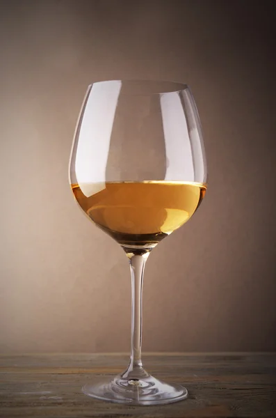 Kieliszek białego wina, na drewnianym stole — Zdjęcie stockowe