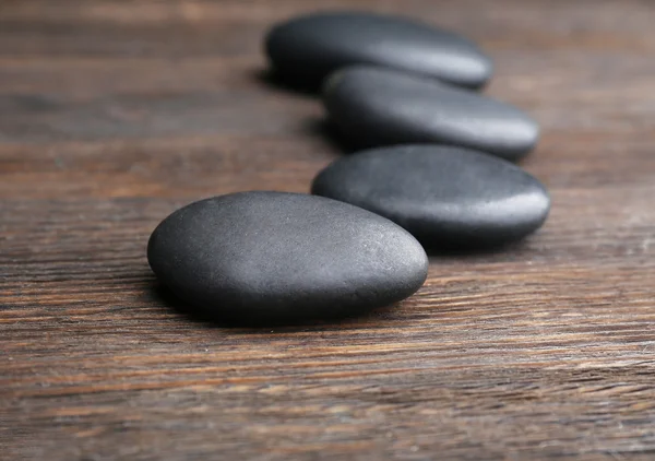 Pebbles em uma fileira no fundo de madeira — Fotografia de Stock