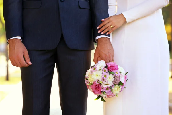 Bride and groom holding wedding bouquet — Stock Photo, Image