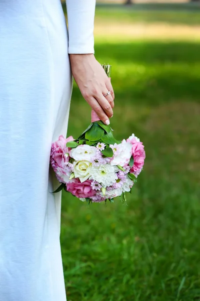 Hermoso ramo de boda en manos de la novia en el fondo de la naturaleza — Foto de Stock