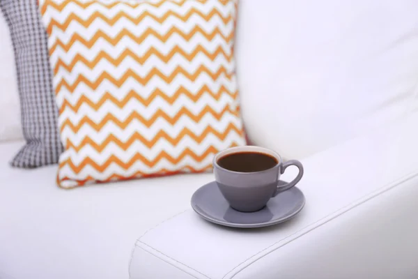 Cup of coffee on sofa — Stock Photo, Image