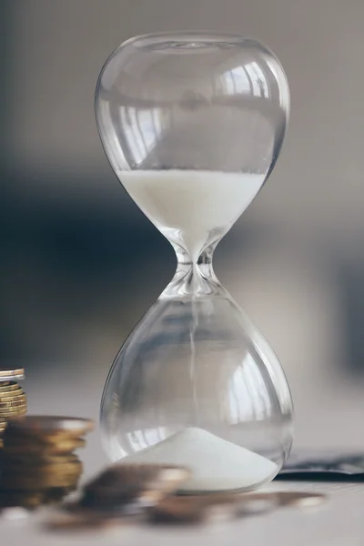 Антикварний пісочний годинник з монетами — стокове фото