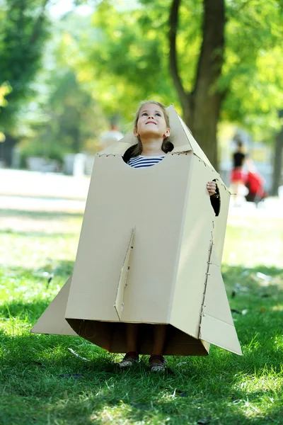 판지 로켓 놀이 있는 어린 소녀 — 스톡 사진