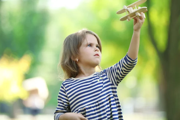 Küçük kız ile ahşap uçak çalış — Stok fotoğraf