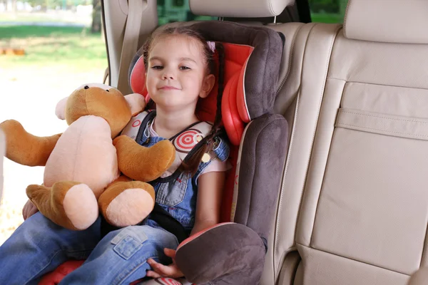 Маленька дівчинка з Тедді сидить в машині — стокове фото