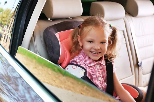 Pequena loira sentada no carro — Fotografia de Stock