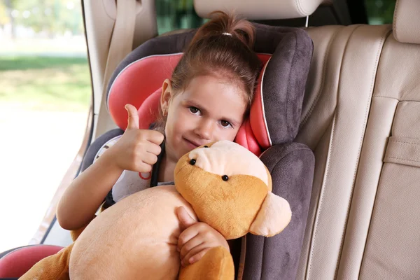 Liten flicka i bilen med nallebjörn — Stockfoto