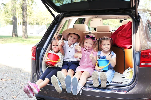 Crianças sentadas no tronco do carro — Fotografia de Stock