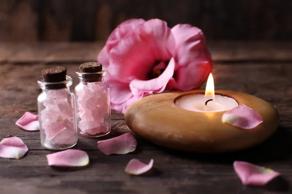 Composition de la tendresse de la bougie allumée avec des pétales de fleurs sur fond en bois — Photo