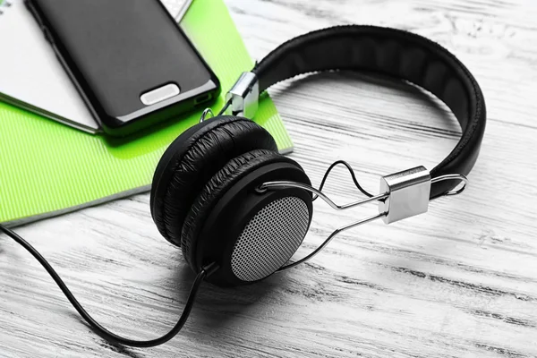 Auriculares con portátiles y smartphone en mesa de madera —  Fotos de Stock