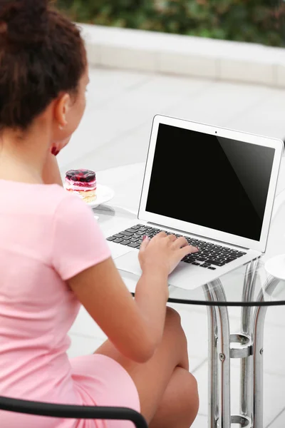 Affärskvinna i rosa klänning med laptop — Stockfoto