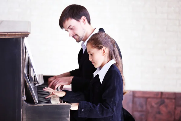 Professeur trains pour jouer piano fille — Photo