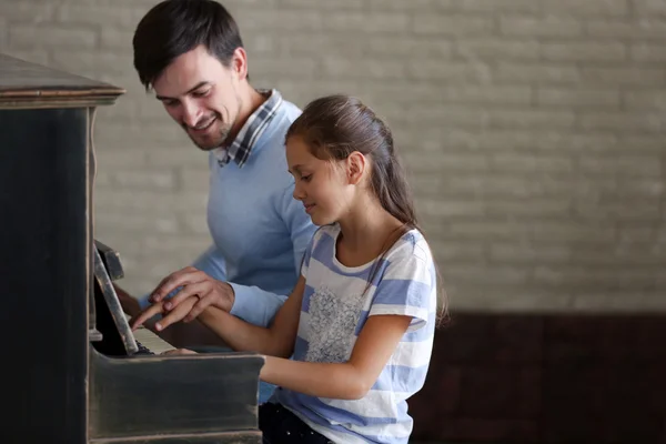 Professor e menina tocando piano — Fotografia de Stock