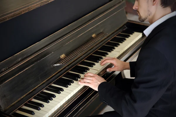 Homme en costume noir joue du piano — Photo