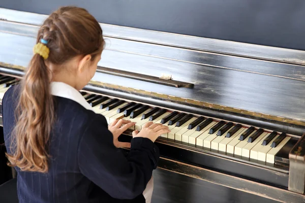 Klein meisje speelt piano — Stockfoto