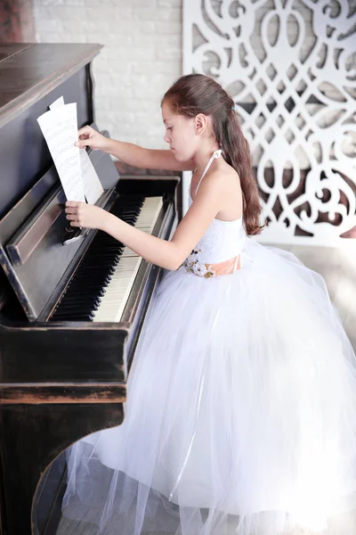 Pequena princesa menina toca piano — Fotografia de Stock