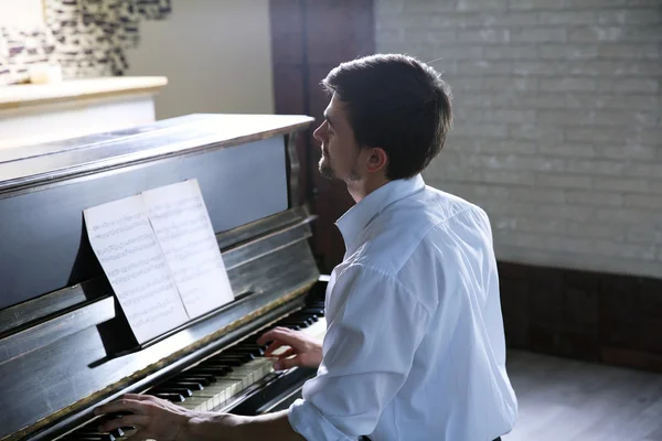 Bonito homem toca piano — Fotografia de Stock