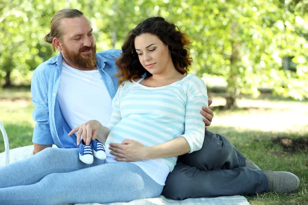 Pregnant woman with her husband in the park — Stock Photo, Image