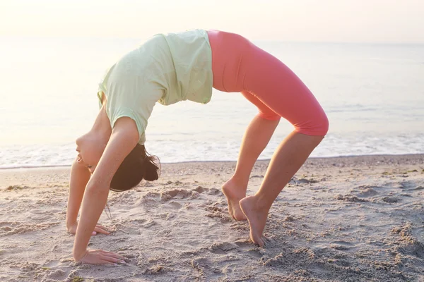 Mujer practica yoga en la playa — Foto de Stock