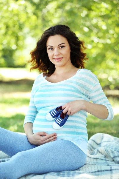 Szczęśliwa kobieta w ciąży z niebieskie botki — Zdjęcie stockowe