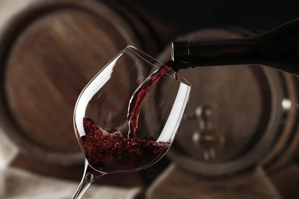 Pouring red wine from bottle into glass Stock Image