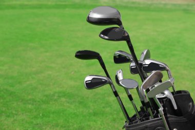 Yeşil alan üzerinde sopalarla golf çantası