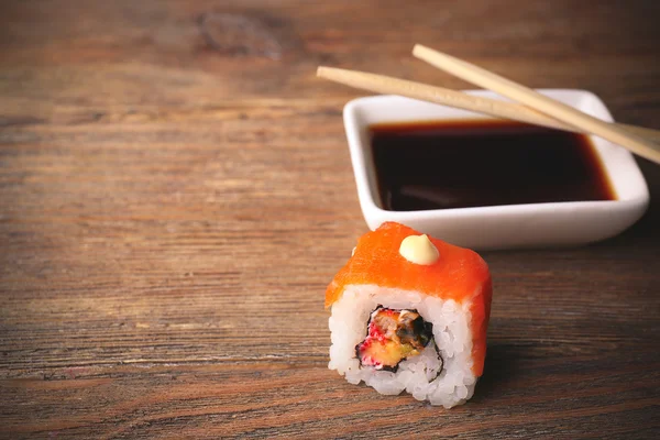 Rollo con salsa y palos en la mesa de madera de cerca — Foto de Stock