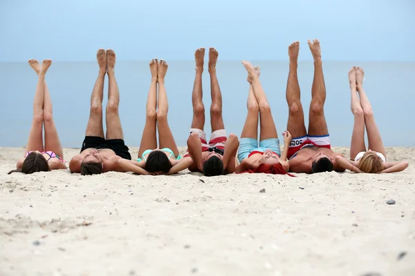 Young people lying on beach — Stock Photo, Image