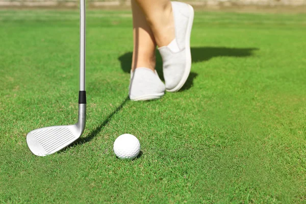 Golfer mit Schläger rollt Ball zum Pokal — Stockfoto