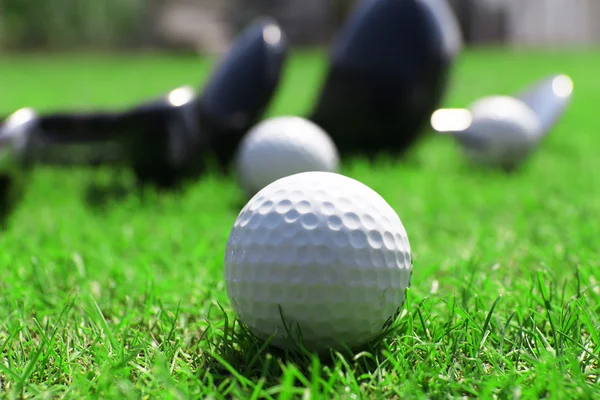 Différents clubs de golf dans une rangée et des balles — Photo